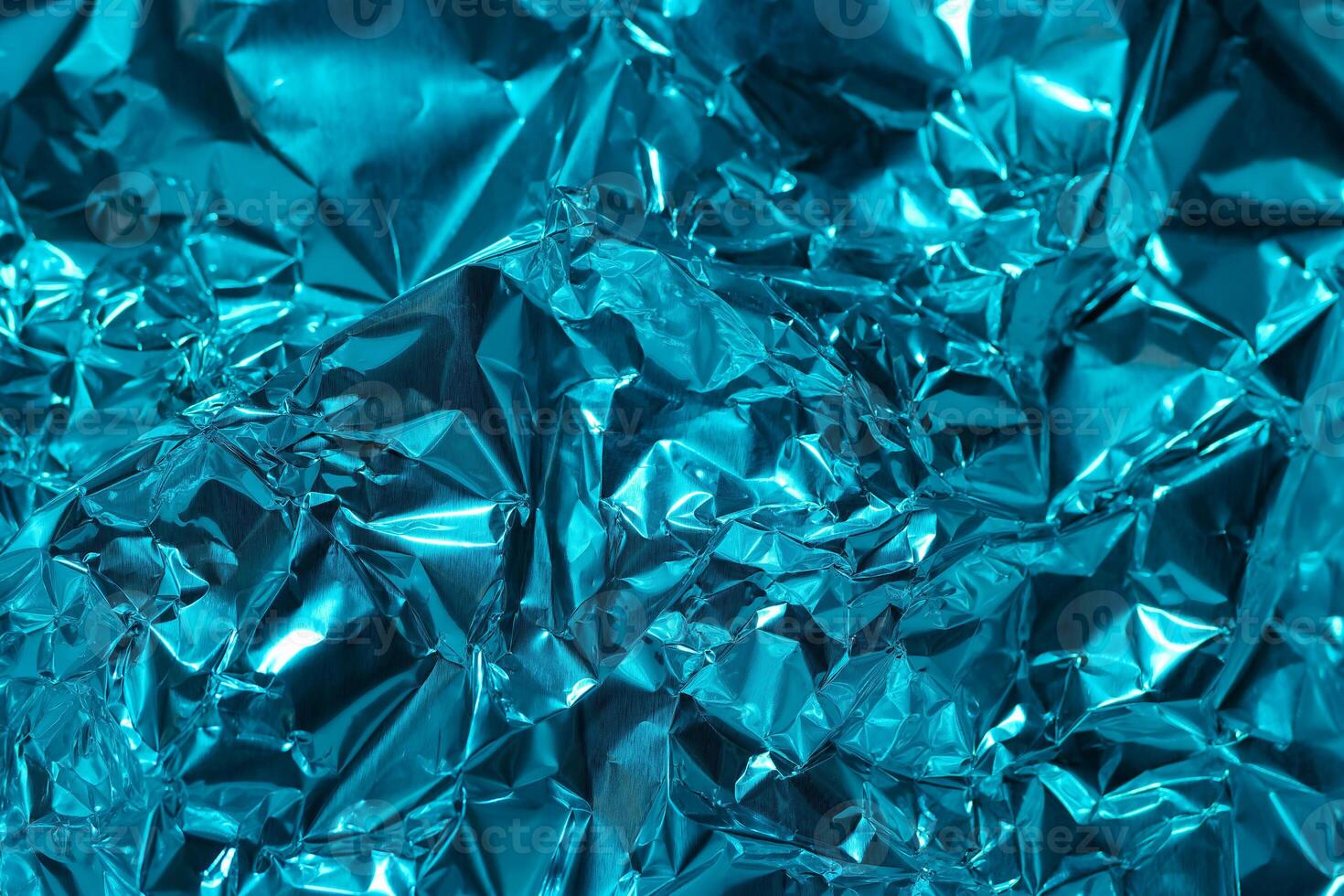Shiny blue foil texture with crumpled surface captured under natural light photo
