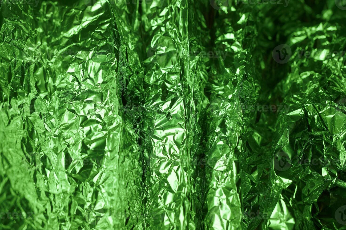 Shiny green foil texture creating a vibrant pattern in natural light during daytime photo
