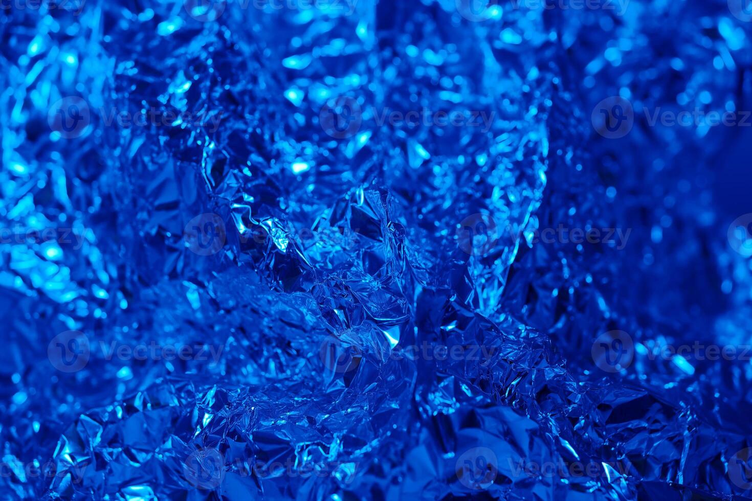 Shimmering blue foil creating an abstract artistic texture with intricate details and reflections in captivating light photo