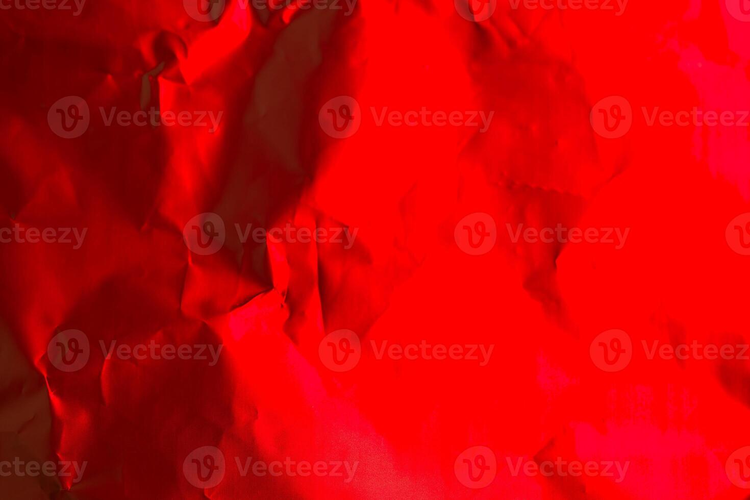 Bright red crumpled paper creates an artistic background for creative design or decoration purposes photo