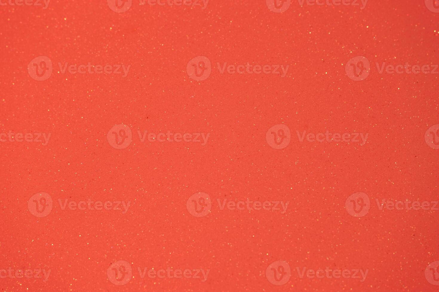 Bright orange textured surface with shimmering particles creating a vibrant aesthetic appeal for design or art projects photo