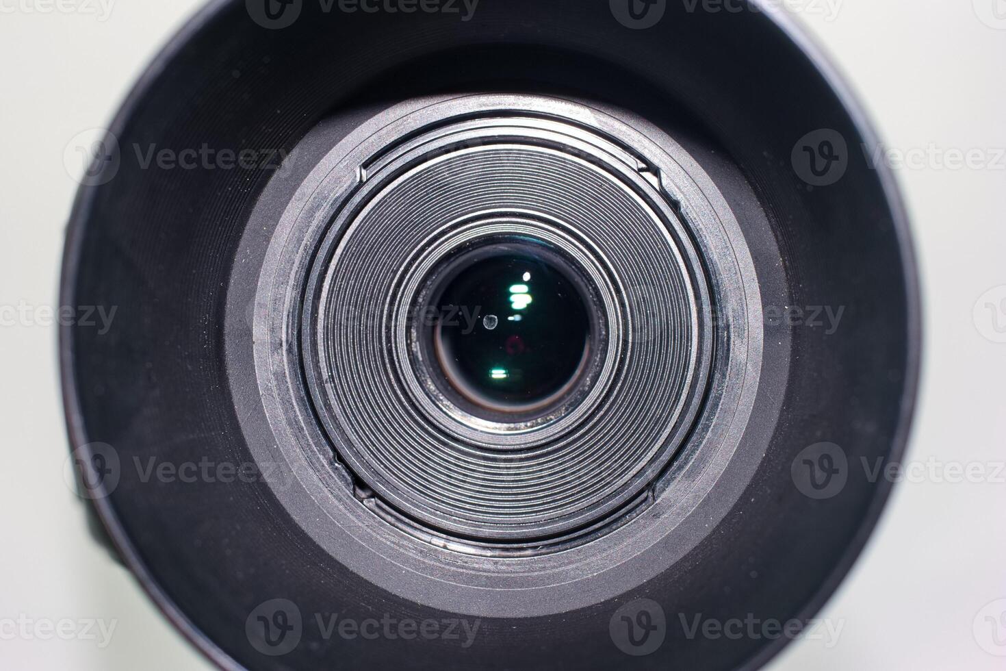 Close view of a camera lens showcasing its intricate details and reflection in natural light photo