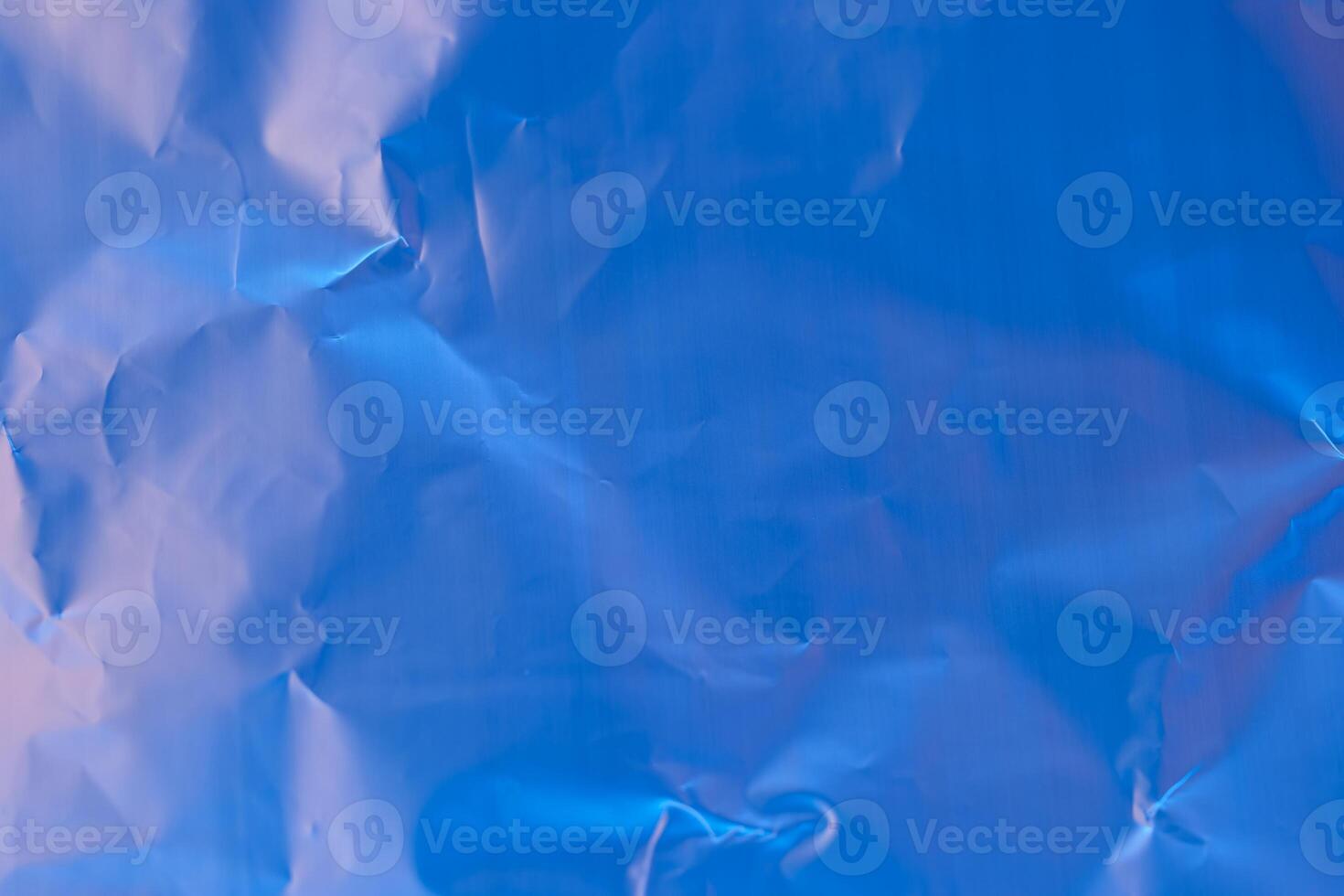 Crumpled blue paper texture showcasing shades of light and shadow in a vivid and abstract composition photo