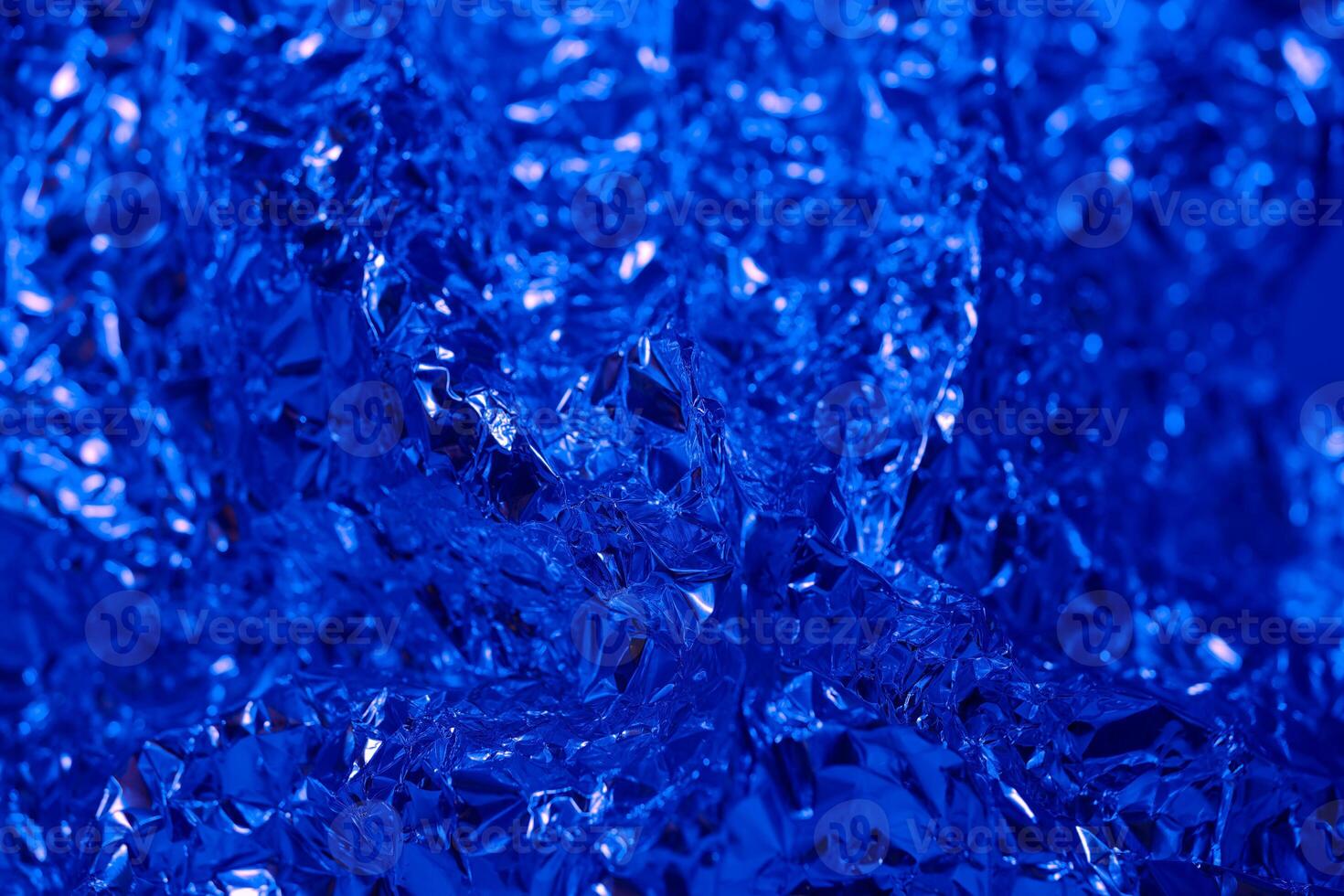 Abstract blue foil texture with shiny and crinkled surface capturing light in unique patterns photo