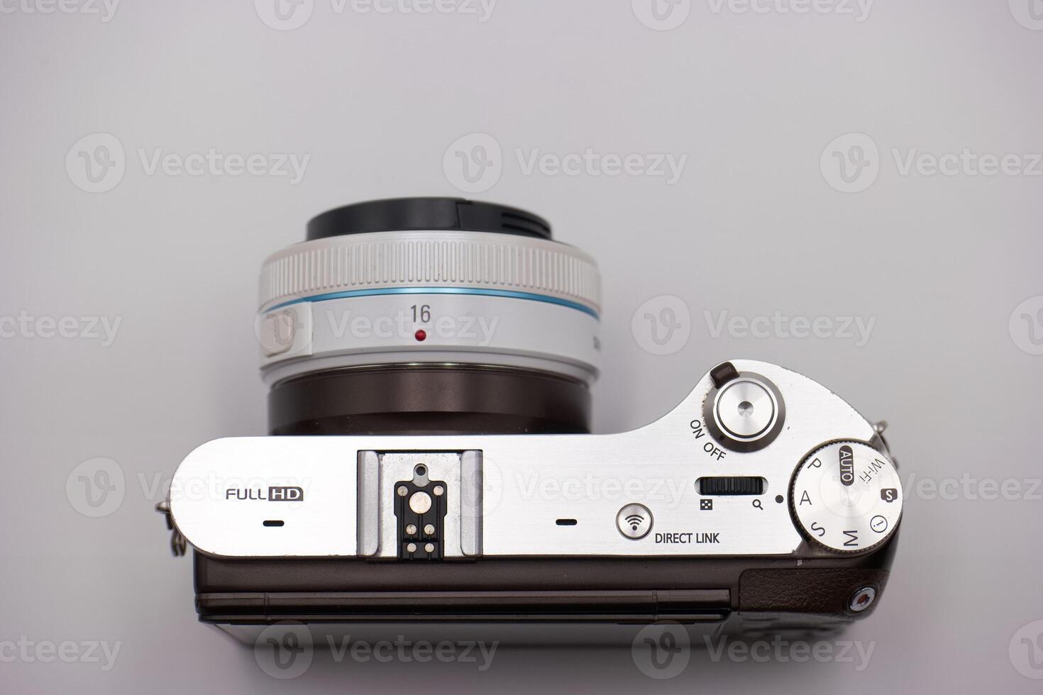 Camera with modern design showcasing control settings and lens details on a neutral background photo