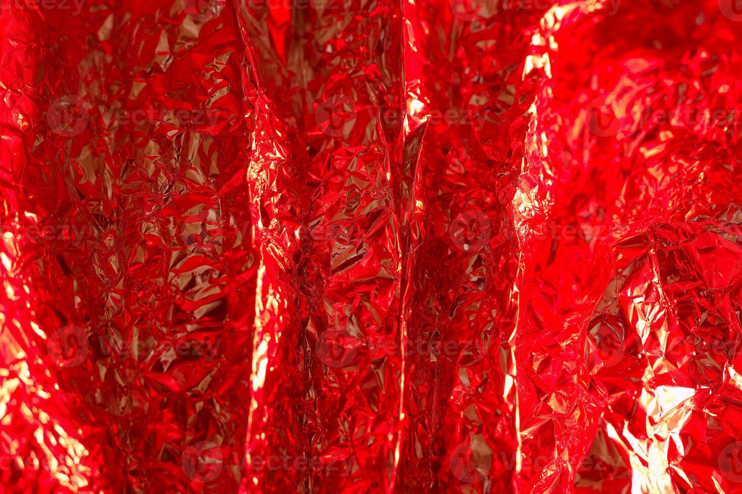 Shiny red crinkled material creating a vibrant and textured visual display for decoration or artistic purposes photo