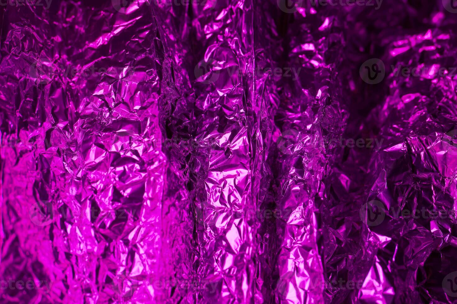 Vibrant purple foil creates a reflective surface with intriguing textures and patterns resembling waves in an abstract setting photo