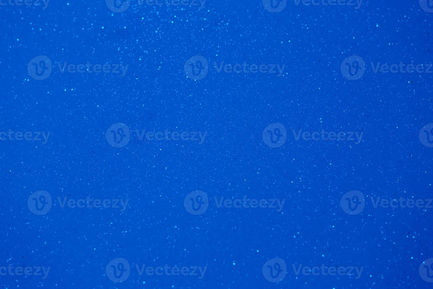 Deep blue background filled with shimmering particles creating a serene and tranquil atmosphere during sunset photo