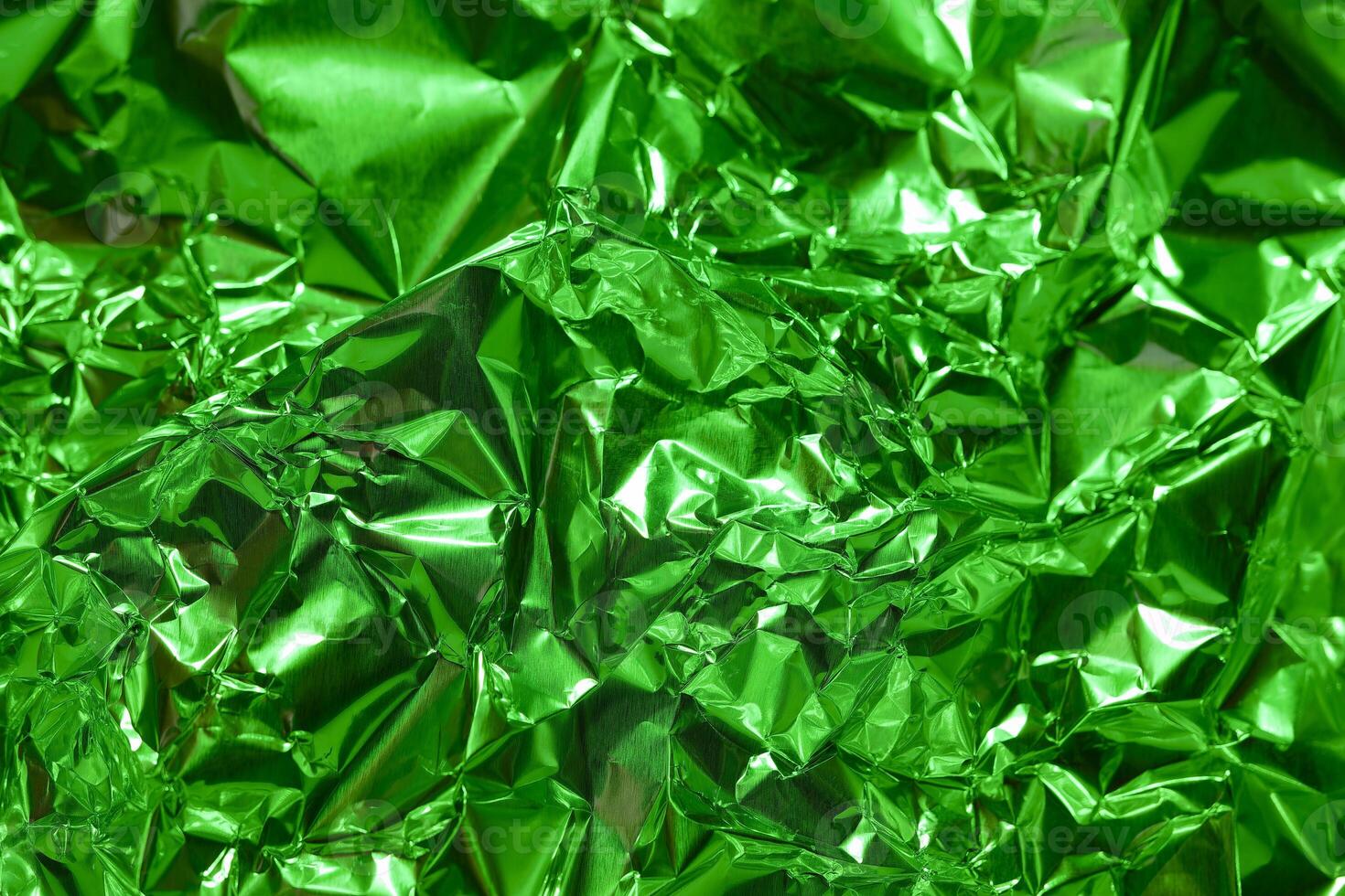 Bright green metallic foil texture creates an abstract and vibrant background for various creative projects photo