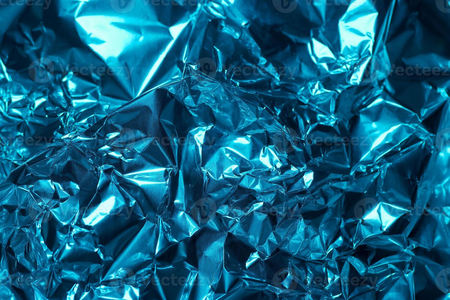 Vibrant blue metallic foil texture evokes depth and complexity in a close up view of crinkled aluminum photo