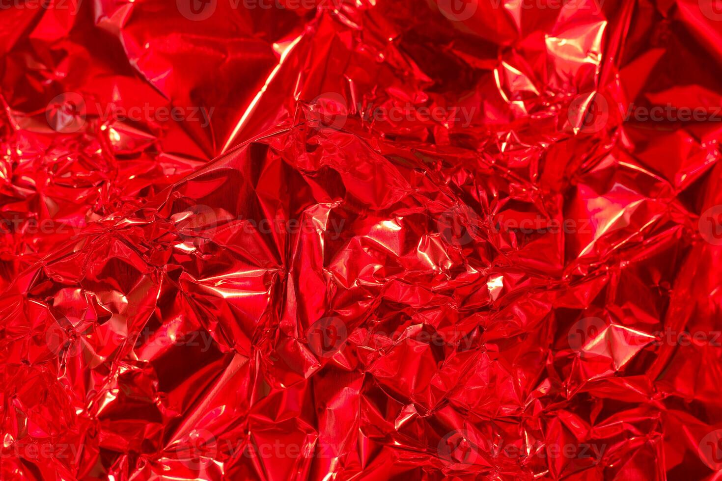 Bright red crinkled foil texture for creative design and artistic projects in various applications photo