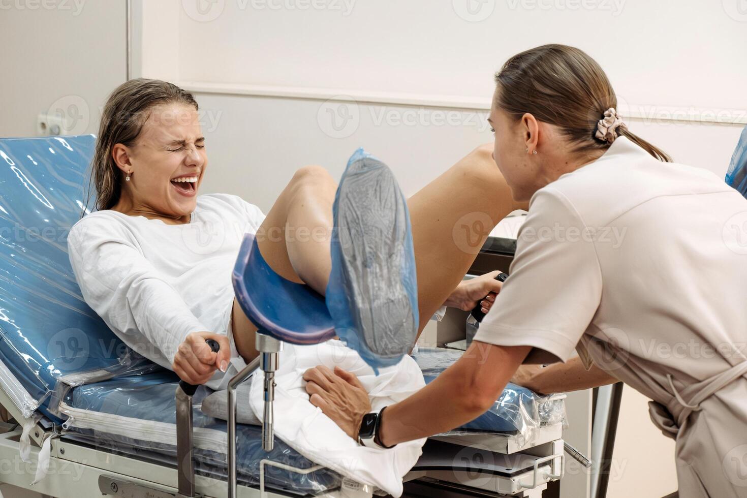 Young woman in labor and contractions in a delivery room on a gynecological chair. Concept of motherhood pain.. photo