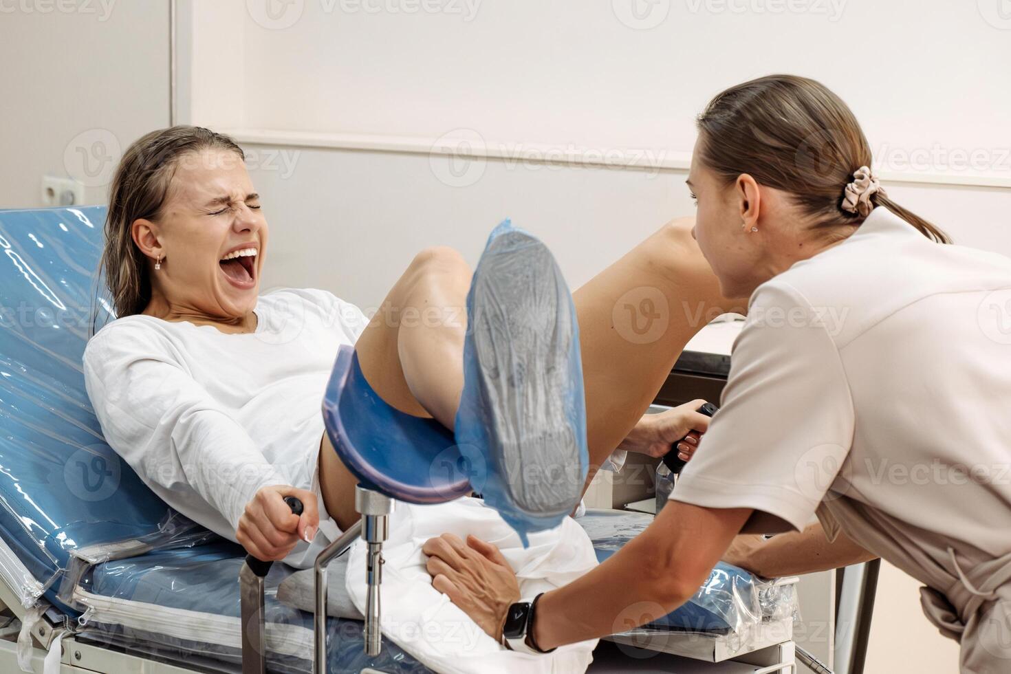 In a delivery room, a young woman is pushing during labor, face tense. photo