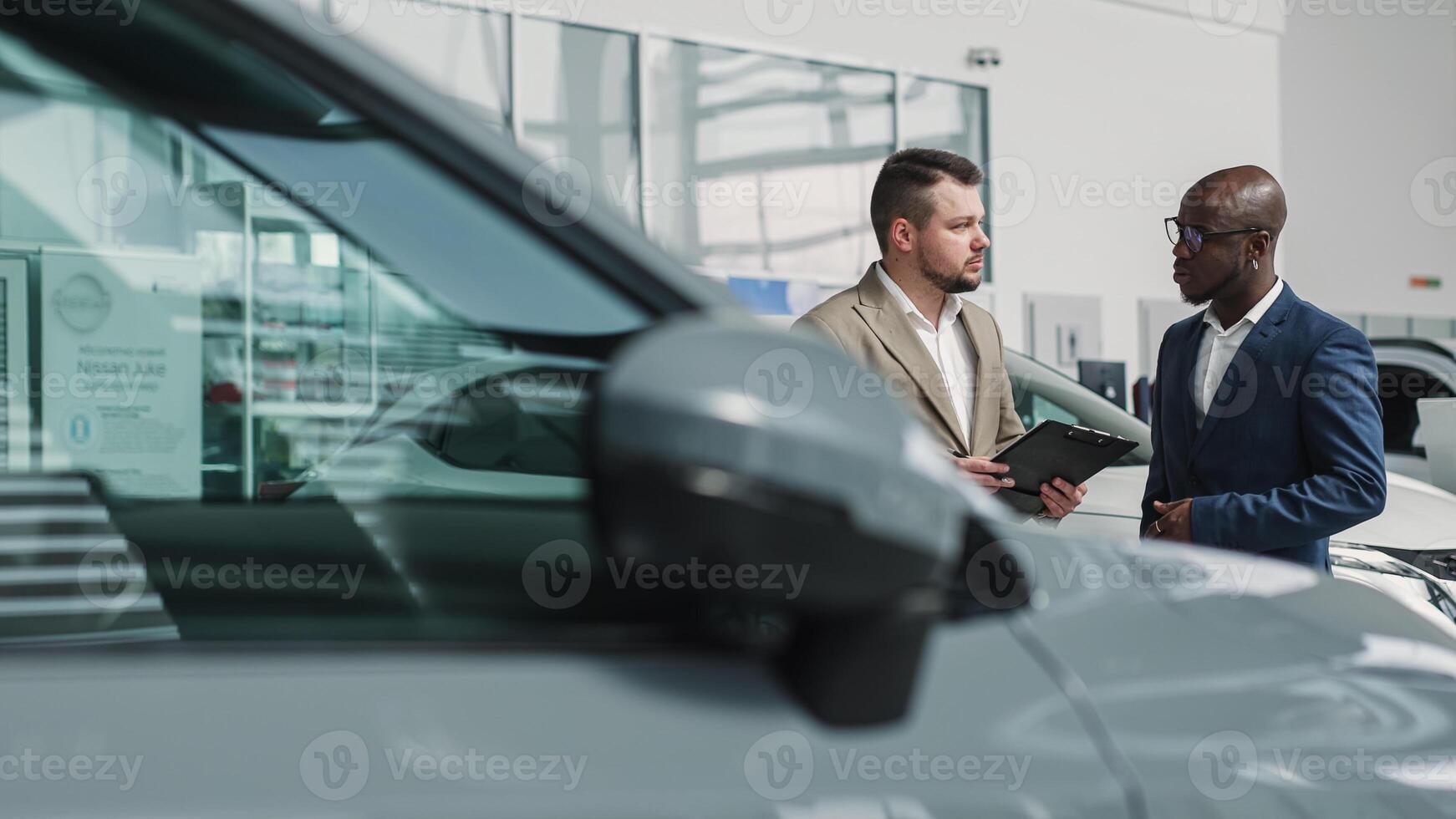 A dealer advises a client on purchasing a modern car at a car dealership. The concept of purchasing, renting and test-driving a new car. photo