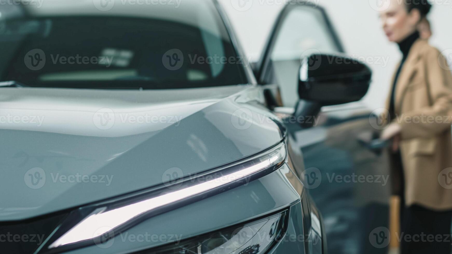 Car sales manager showing a car to a customer in a car showroom. Purchase concept and assistance photo