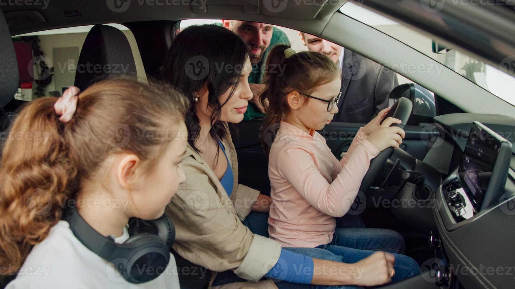 In a modern car dealership, a manager shows and advises a young family with children about buying or test driving a modern car. The concept of buying or leasing a new car. photo