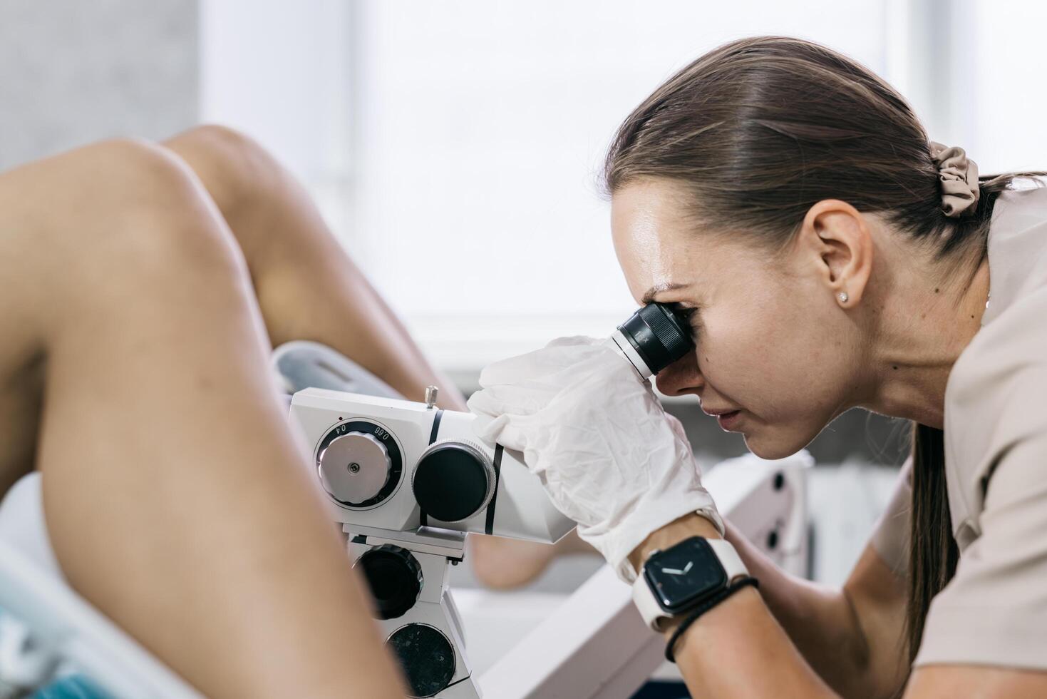 Gynecologist uses colposcope to examine cervix. Concept of women's health photo