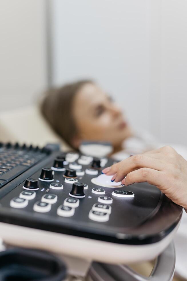 Concept early pregnancy monitoring and fetal health. Young pregnant woman undergoing ultrasound diagnosis at clinic. photo