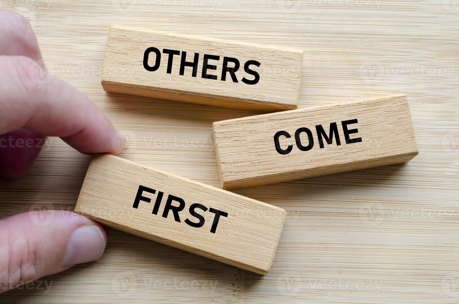 Others come first message on wood blocks, reinforcing the idea that effective leadership involves serving and uplifting others consistently photo