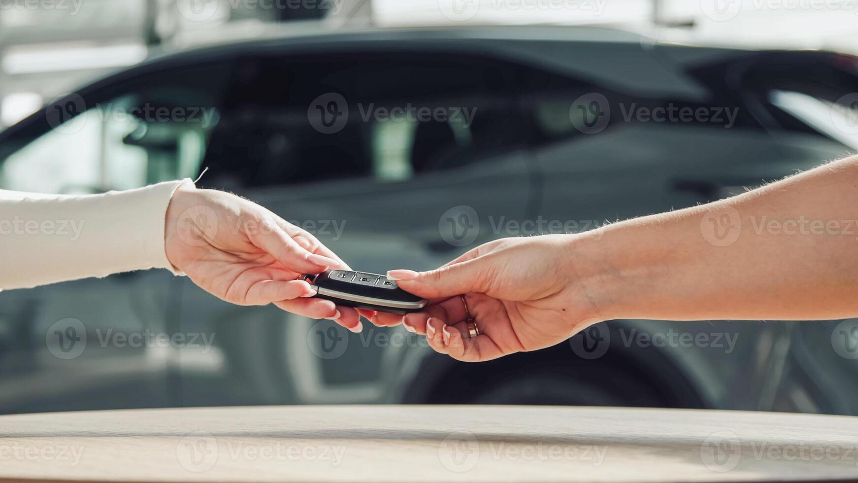 Closing the car purchase transaction with the delivery of the keys. The concept of the final stage of a flawless purchase, sale or test drive of a car, emphasizing the customer's satisfaction photo