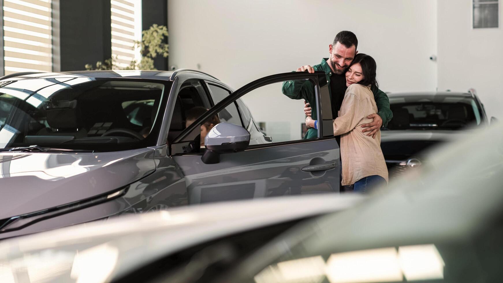 Happy family in a modern car showroom after buying a new family car. Car rental and test drive concept photo