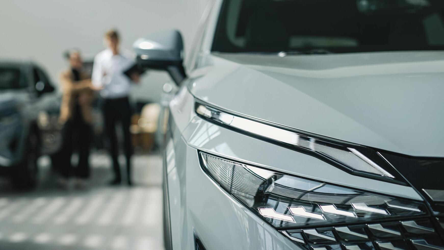 Purchase concept and assistance. Car sales manager showing a car to a customer in a car showroom. photo