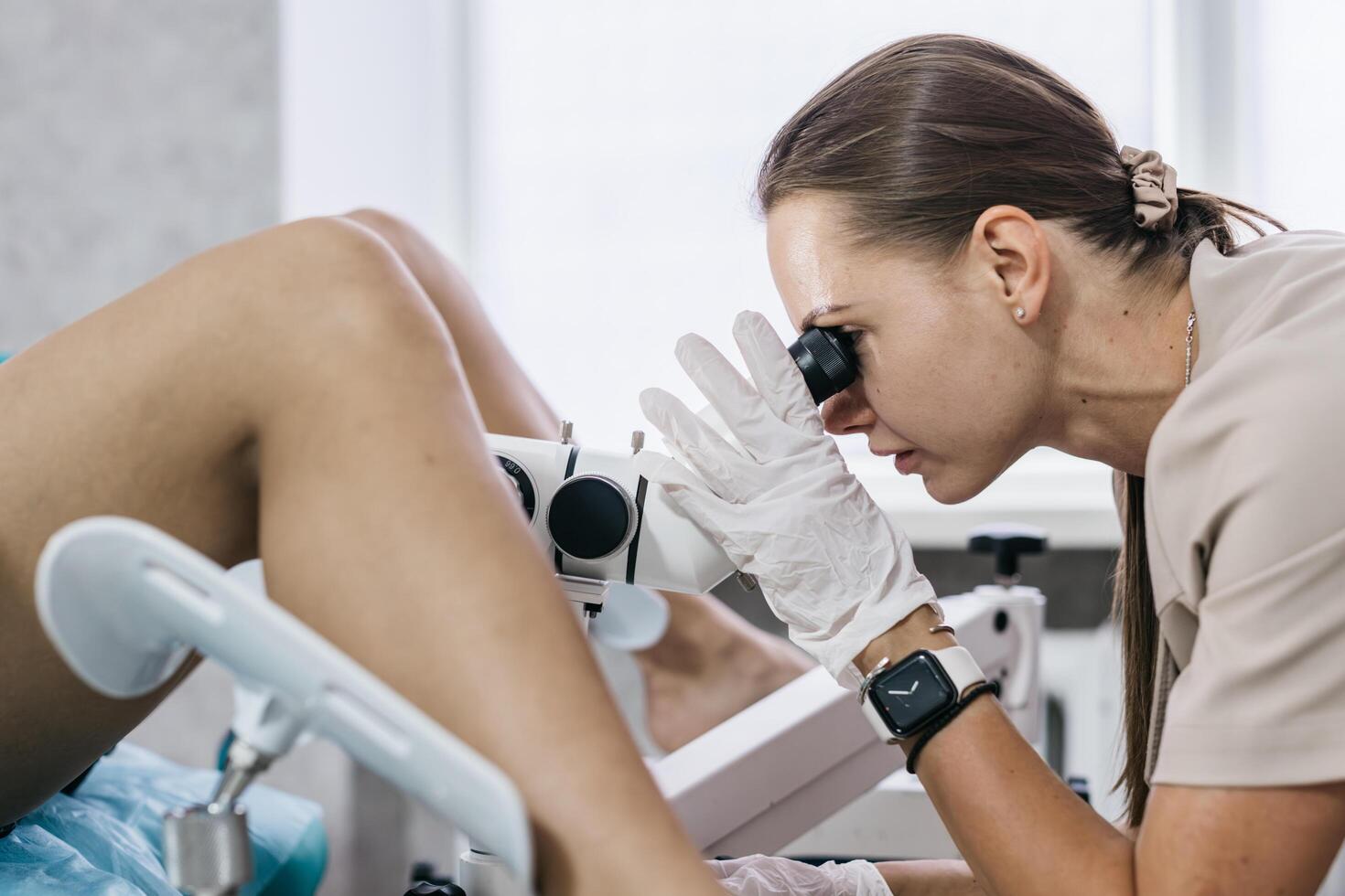 Close up of gynecologist using colposcope to examine cervix. Concept of women's health care photo