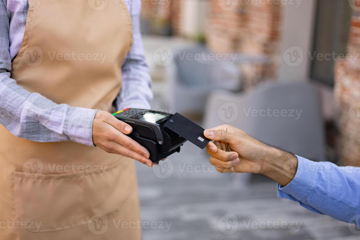 A female waiter with a cash register and a portable terminal asks to pay for the order. photo