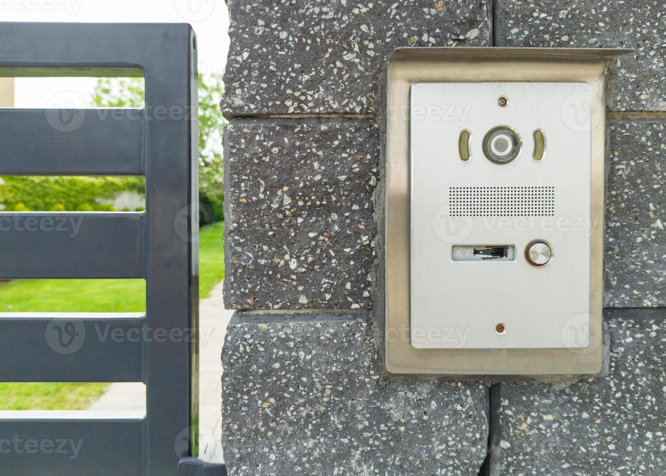 Stainless steel intercom on brick pillar photo