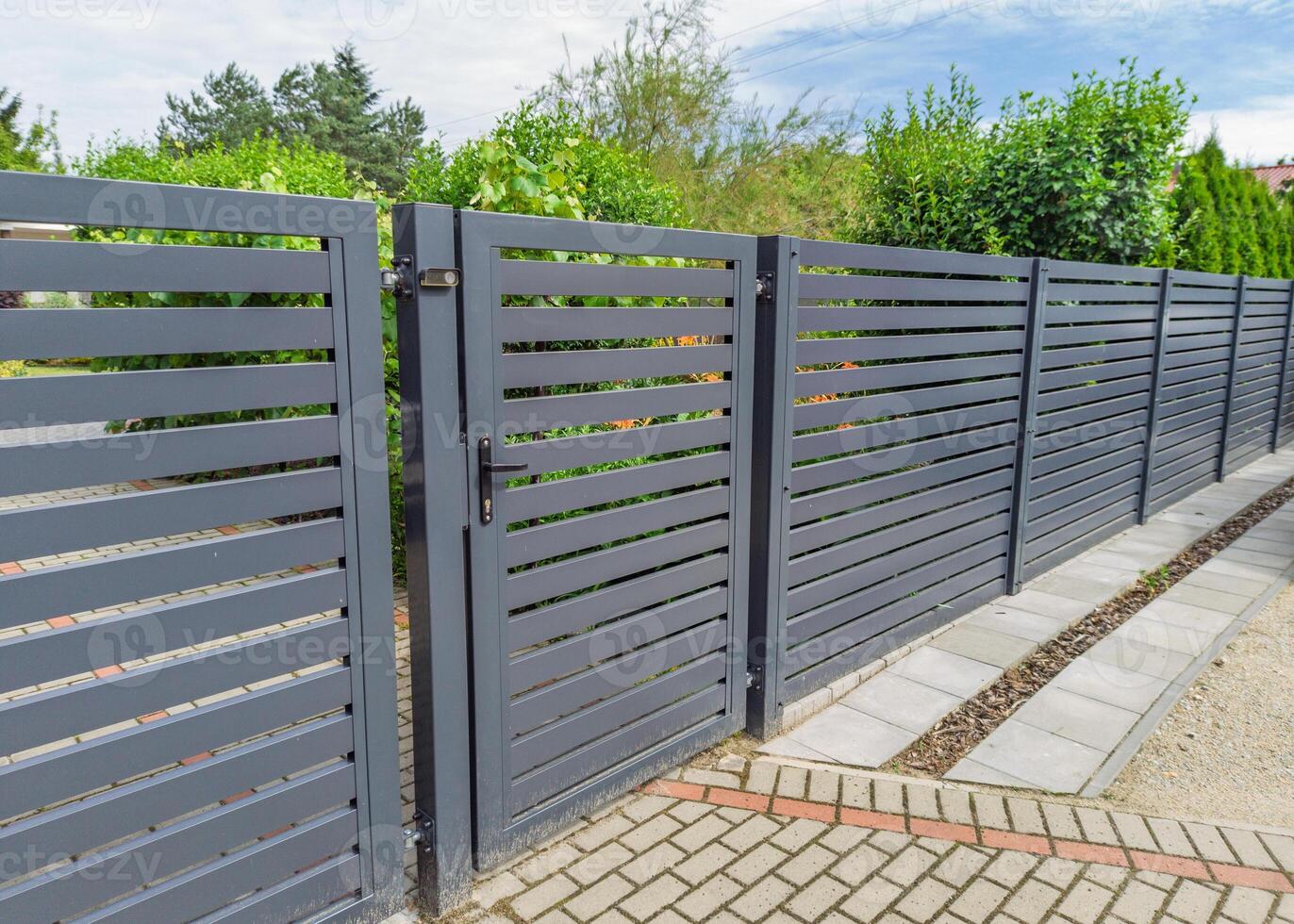 Modern metal fence with garden gate photo