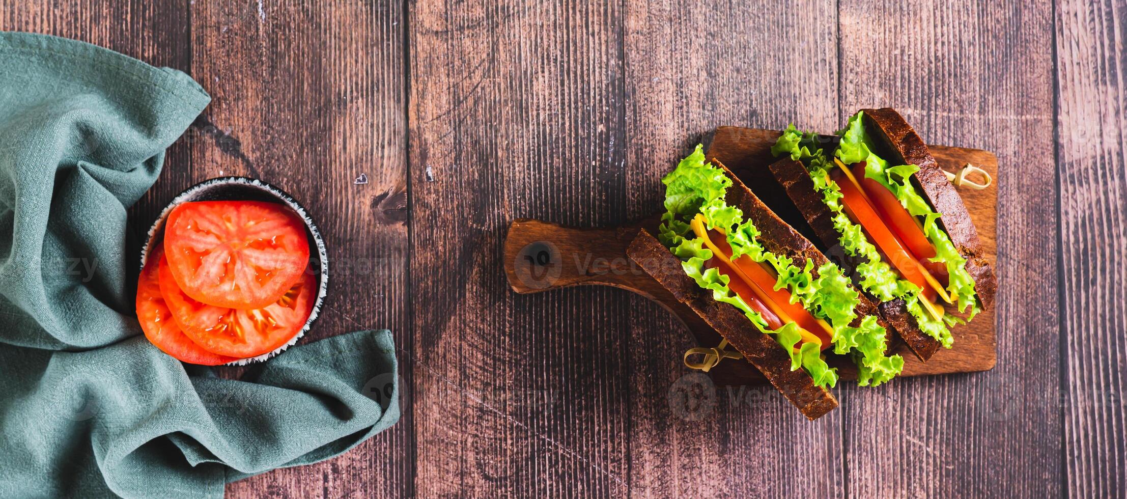 Light sandwich with vegetables and cheese on rye bread on a board top view web banner photo