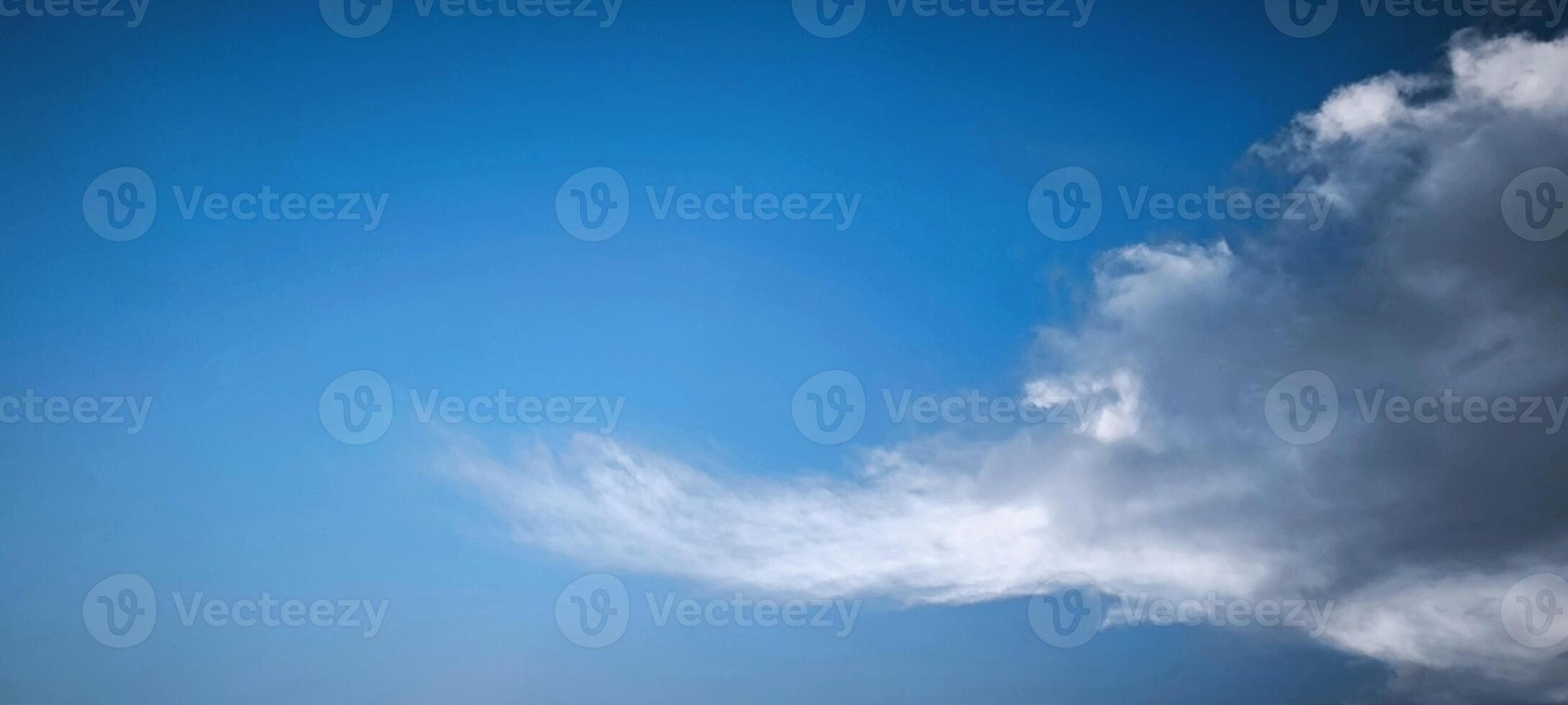 view of fluffy white clouds scattered across a bright blue sky, perfect for background, nature, weather, travel, and peaceful landscape concepts. photo
