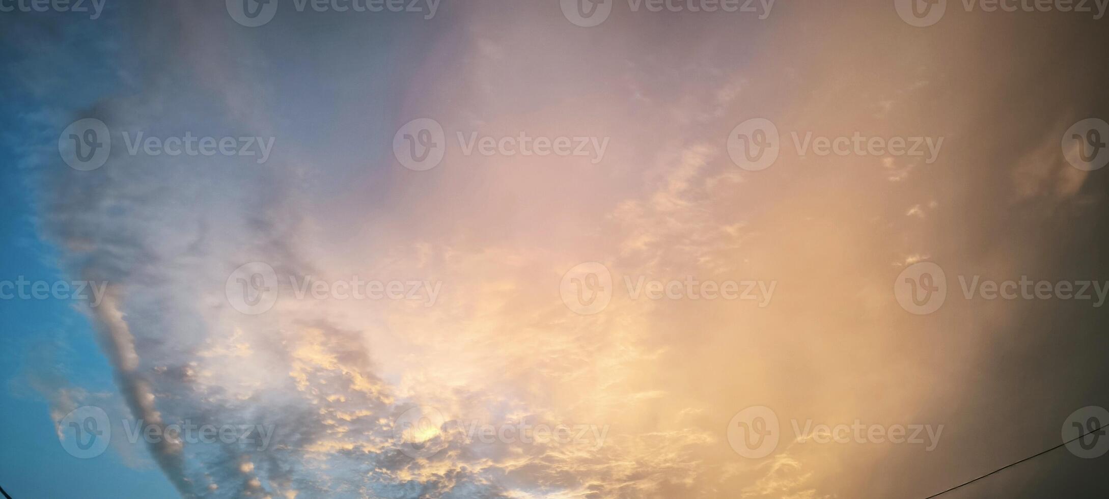 Photo of beautiful orange reddish clouds during sunset against a bright blue sky, creating a stunning contrast perfect for nature, sky, weather, and landscape themes