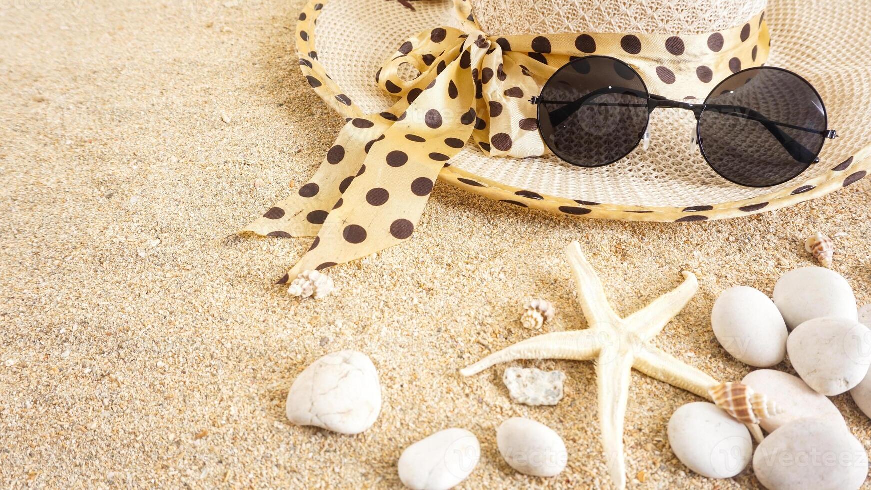 Top view flat lay of summer holiday concept with summer hat, sunglasses, and sea creatures isolated on beach sand background photo