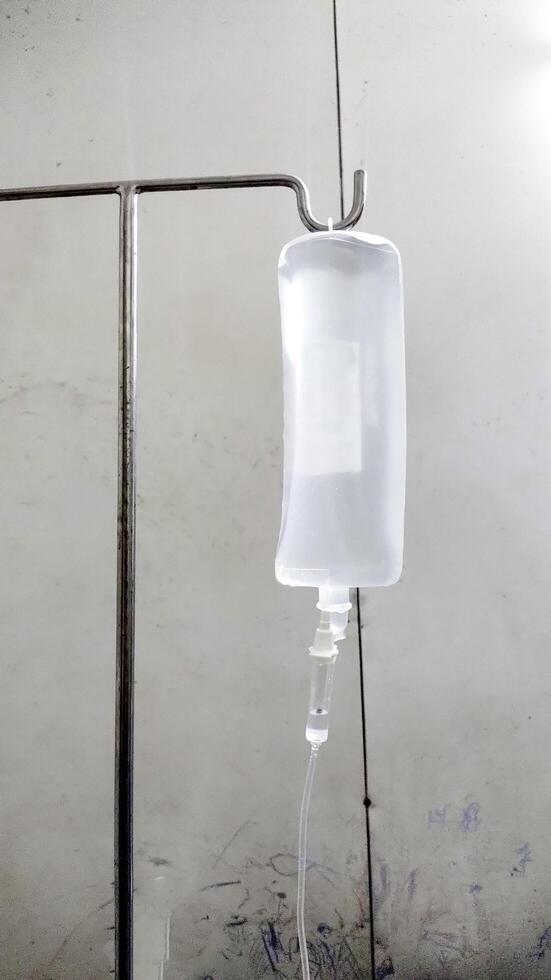 A Medical IV Drip Hanging on Stand in Hospital Room photo