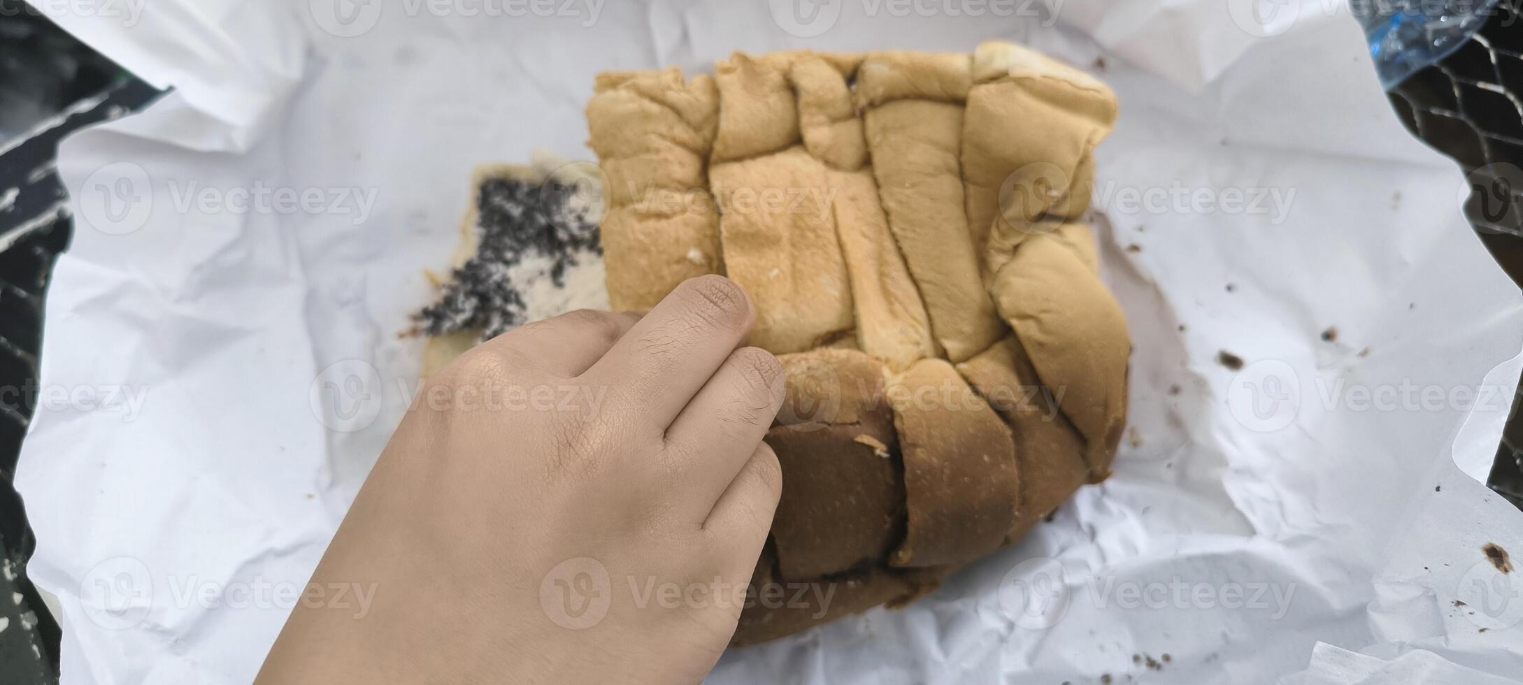 Photo of pull apart bread filled with cream and chocolate sprinkles, with a hand reaching to take a piece, perfect for bakery, dessert, and food themes.