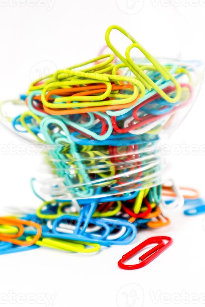 Vibrant Multi-Colored Paper Clips Overflowing from a Container on a White Background photo