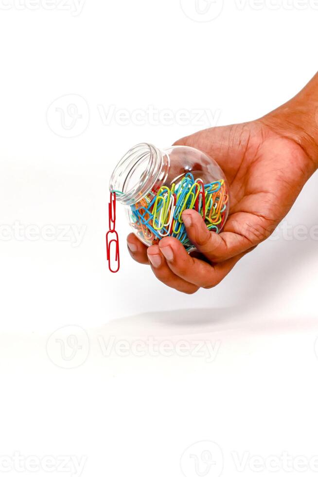 Paper Clips in a Jar Held by a Hand on White Backdrop - Isolated Object photo