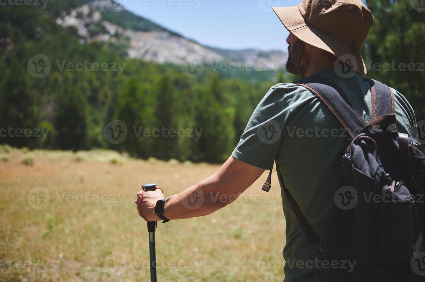 Bearded Man Exploring Nature with Backpack on a Sunny Summer Day photo