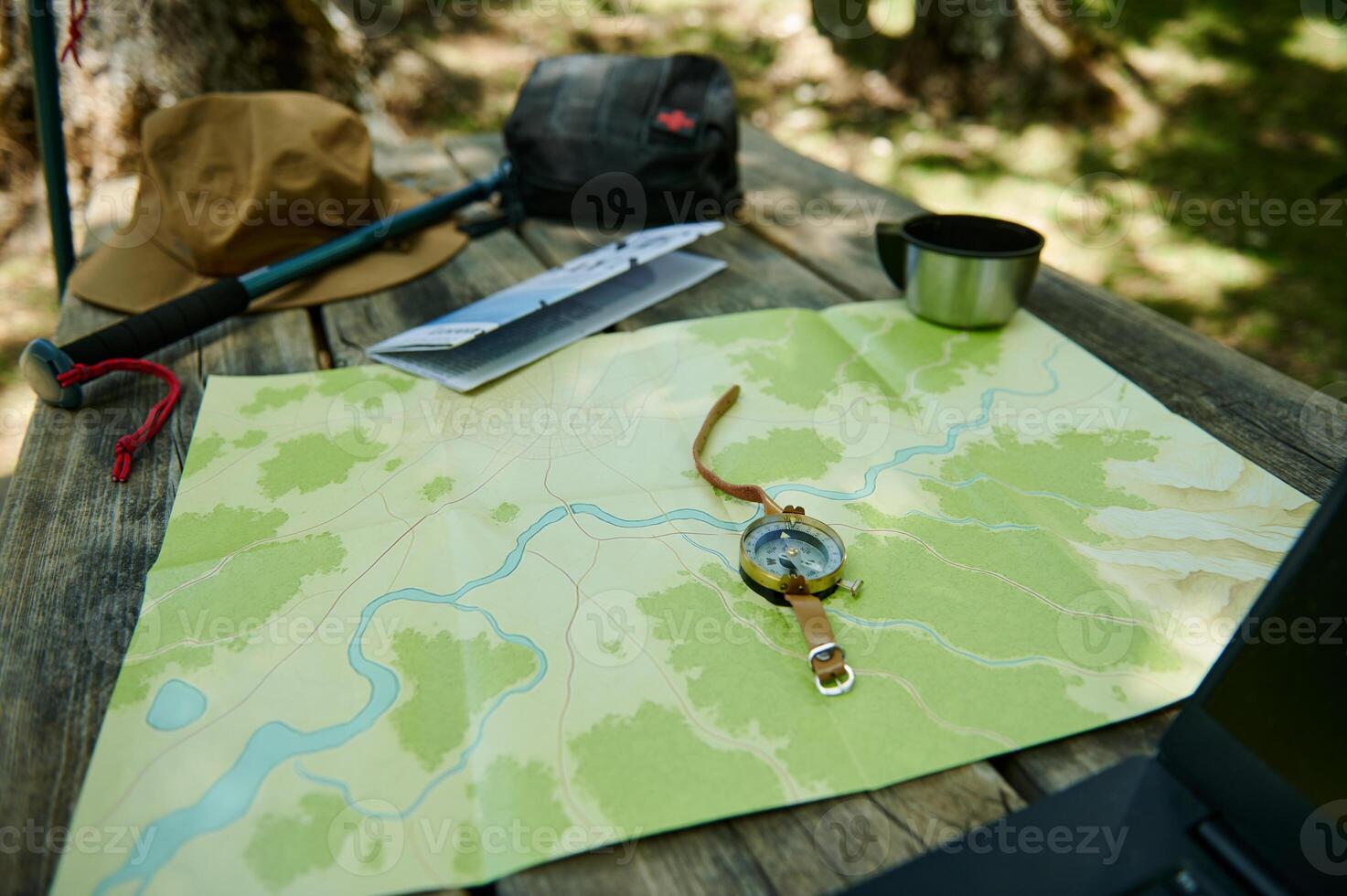 Comprehensive Camping Setup on Wooden Table with Map and Compass photo