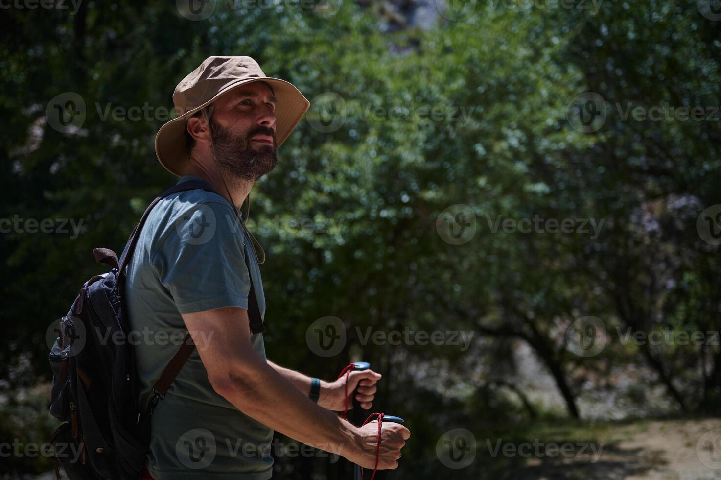 Man Hiking in the Mountains on a Summer Day with Backpack and Hat photo