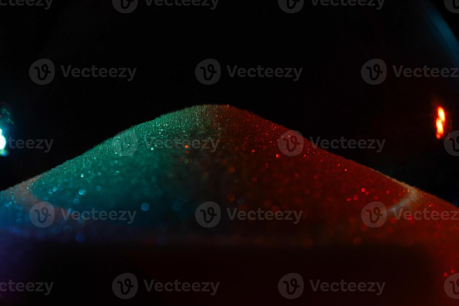 Rainbow sparkly hourglass sand on dark background. Minimalist low key poto for concepts of time, travel to the desert photo