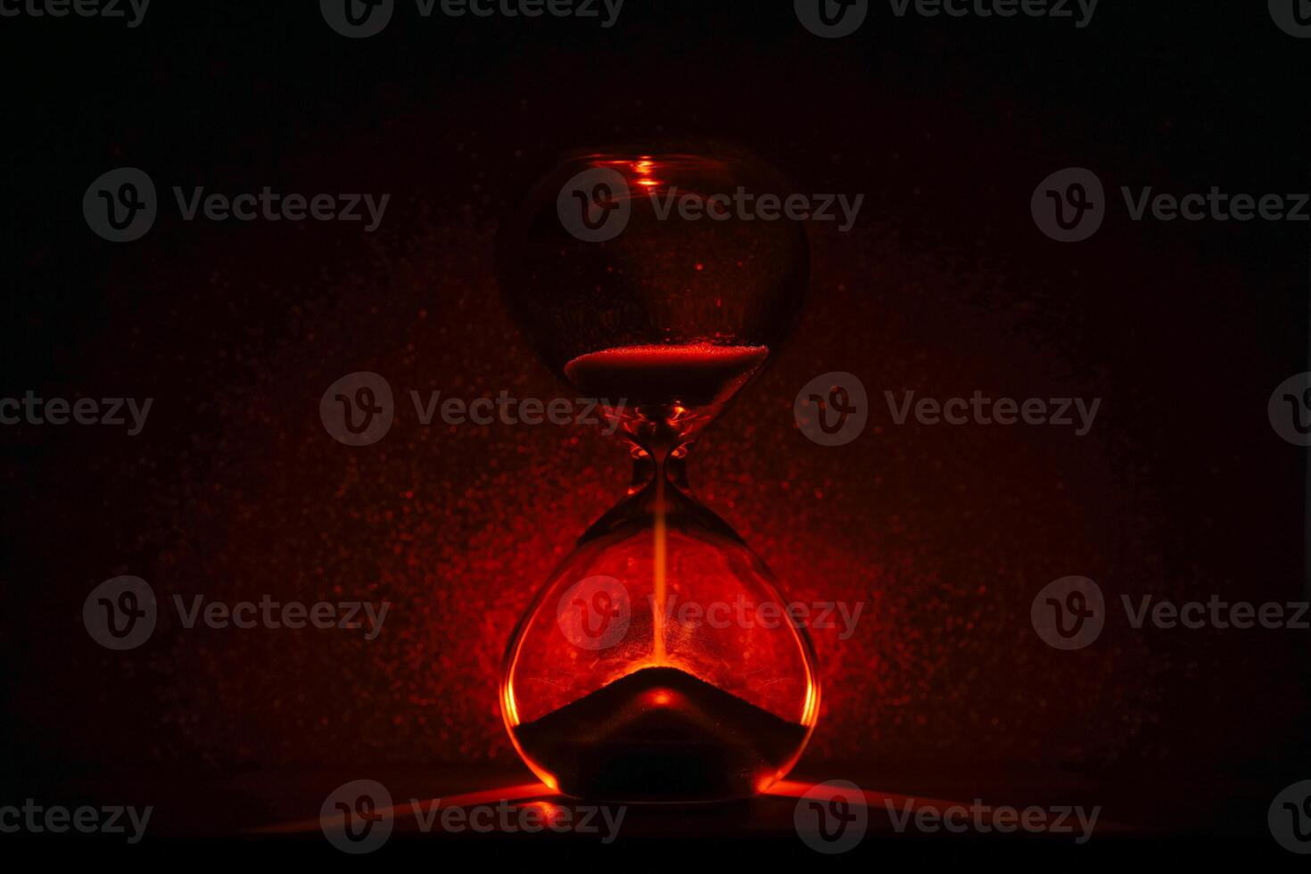 artistic glowing hourglass like sunrise or sunset, symbolizing time and creativity. Vibrant lighting against a dark minimalist backdrop. Concepts of time management, life balance, and artistic design. photo