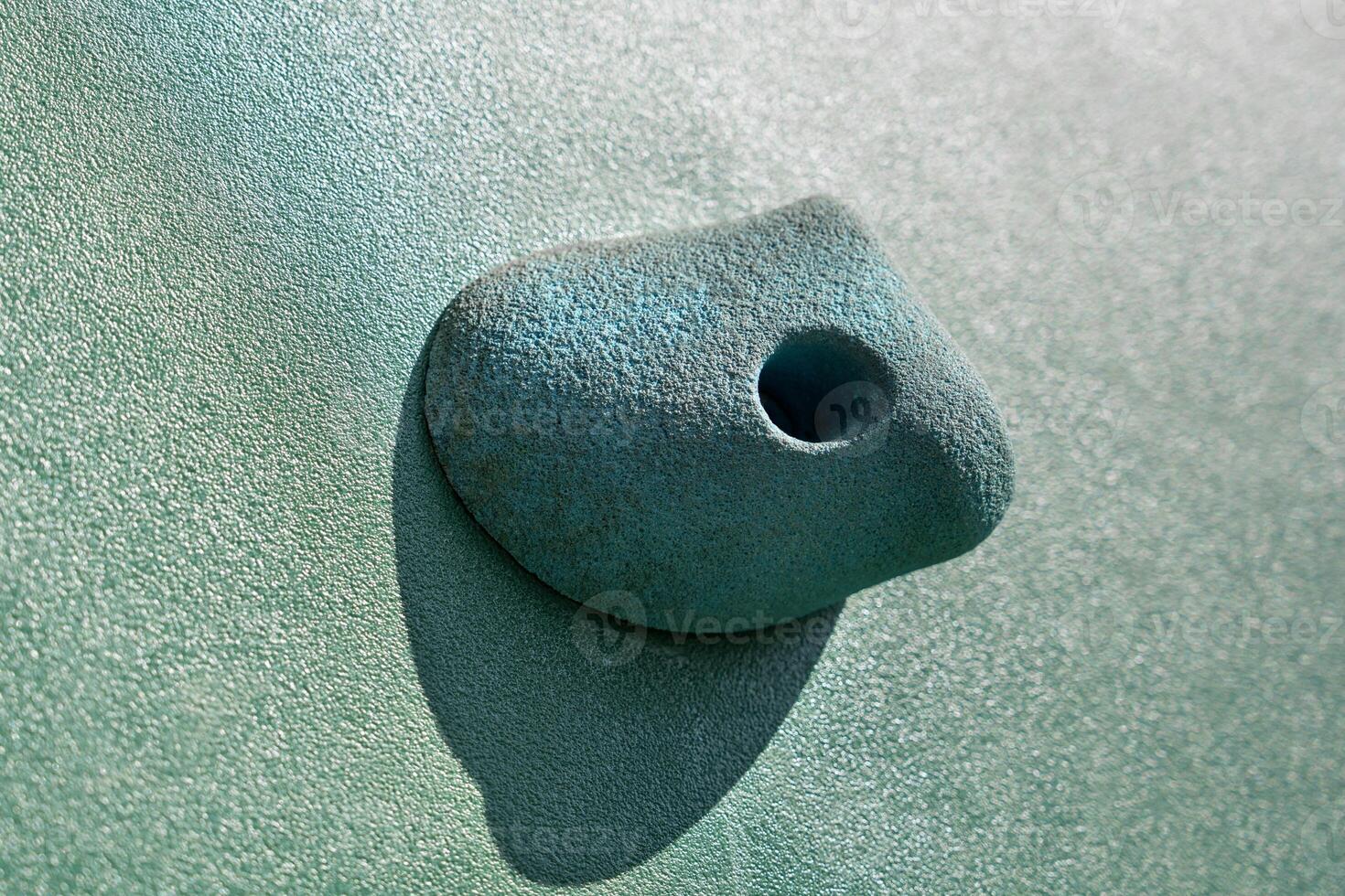 An artificial blue climbing hold on a wall. Close up photo