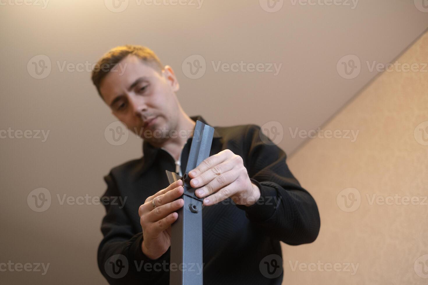 Man assembling furniture at home with his own hands expert in furniture repair and assembly services. photo