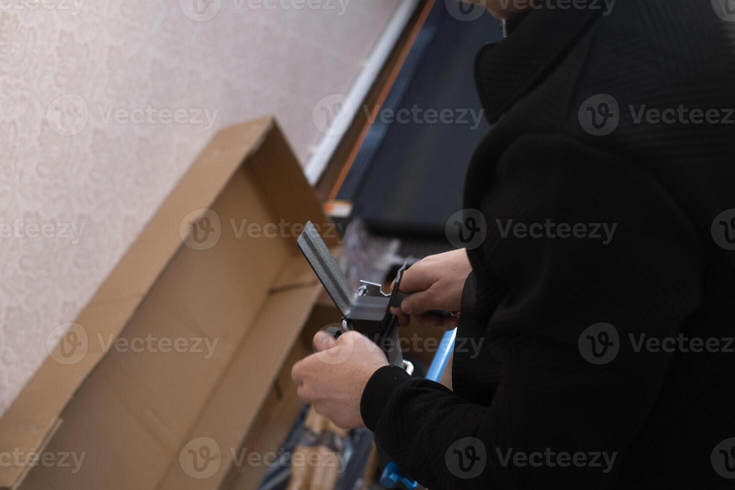 Man repairs and assembles furniture by himself showing professional approach and attention to detail at home. photo