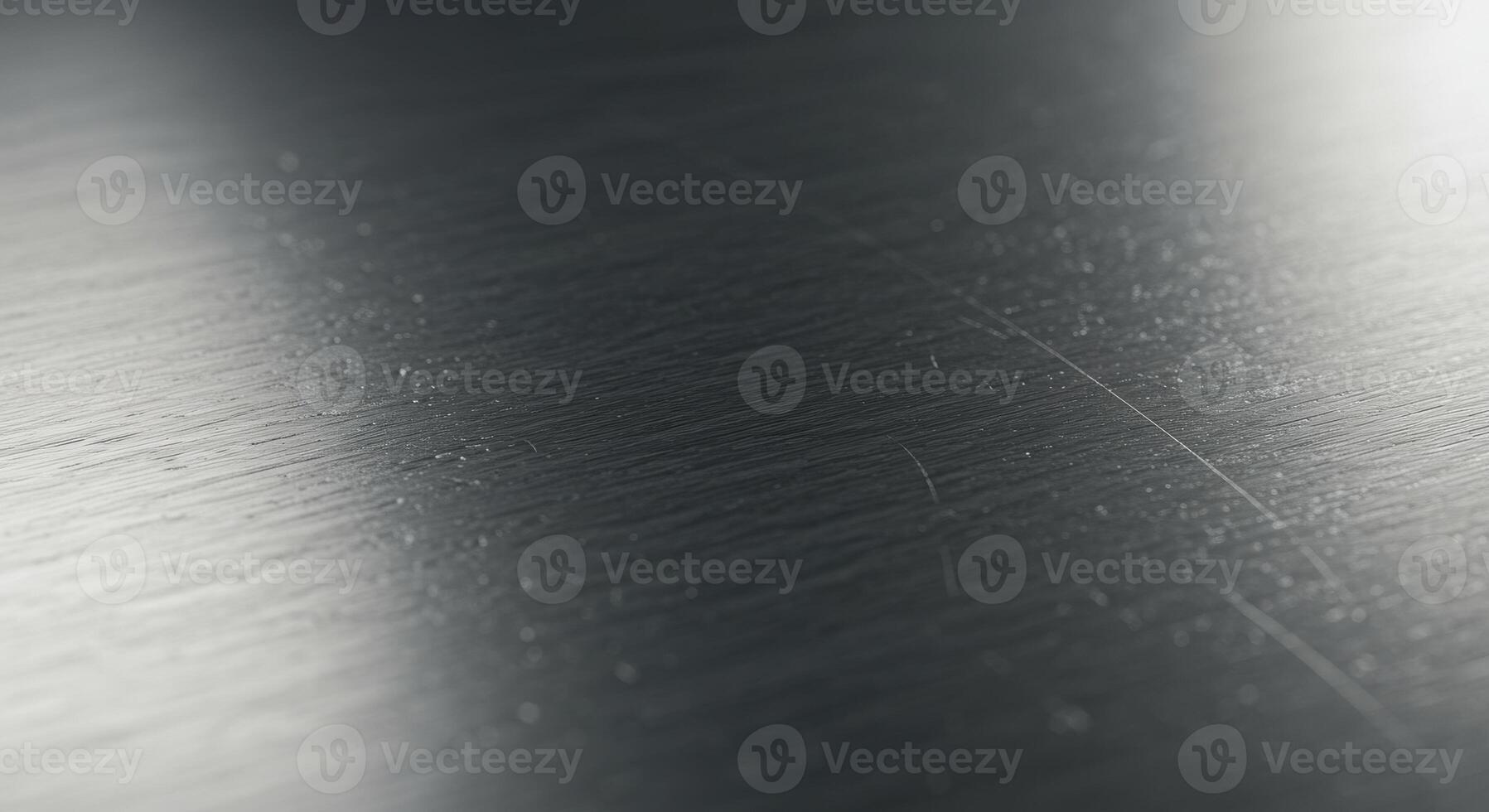 Close up view of a dark gray brushed metal surface showing texture and subtle scratches photo
