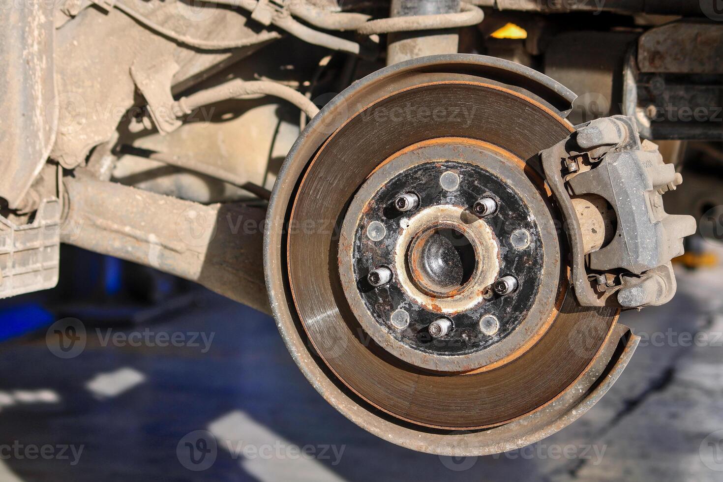 Close-up of a car brake disc, showing wear and rust. This image is perfect for showing car repair, maintenance or mechanical engineering. photo