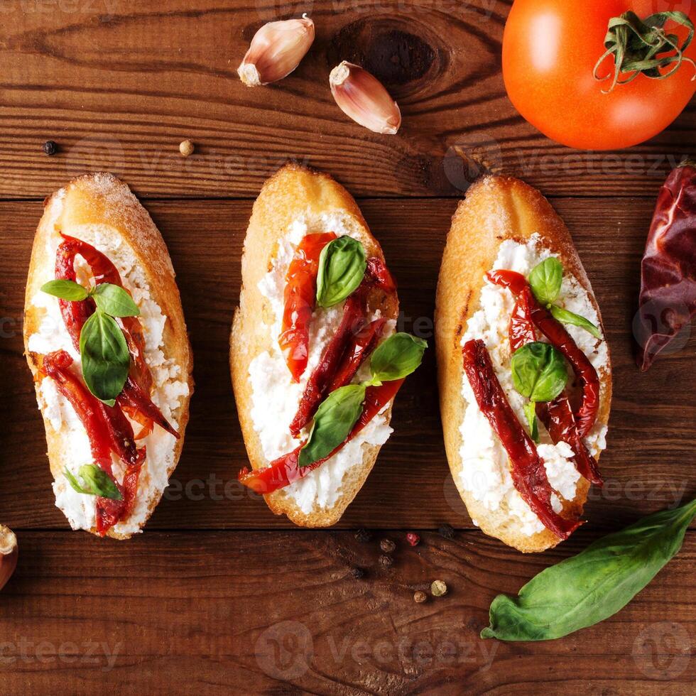 Italian sandwiches - bruschetta with cheese, tomato and basil. Top view photo