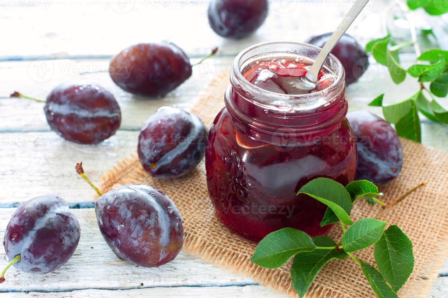 Jar of plum jam with fresh plums photo